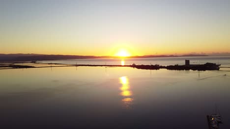 Atemberaubende-Antenne-Des-Sonnenaufgangs-über-Friedlichem,-Ruhigem-Lagunenwasser,-Vorwärts-Fliegend