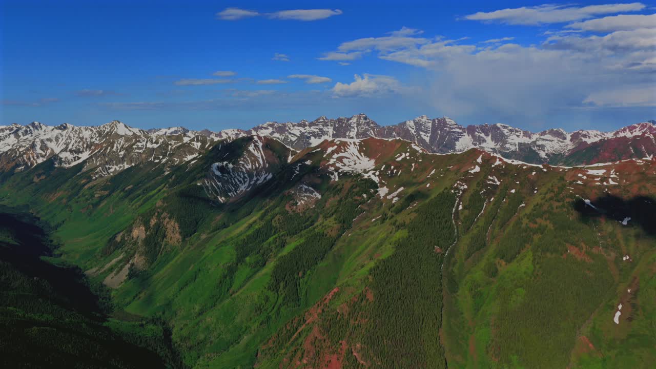 Castle Creek summit Aspen Highlands bowl spring summer Maroon Bells Wilderness Pyramid Peak Elk Mountain Range aerial drone Colorado Snowmass Mountain Capitol Peak sunny morning blue sky cloud forward