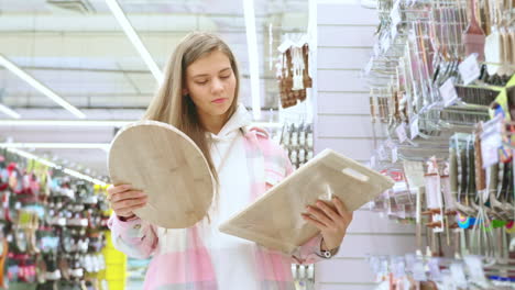 mujer comprando tablas de cortar en una tienda de suministros de cocina
