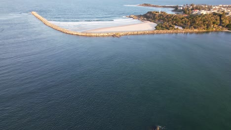 tilt-up reveal of south break wall and turners beach at the mouth of clarence river in yamba, nsw, australia