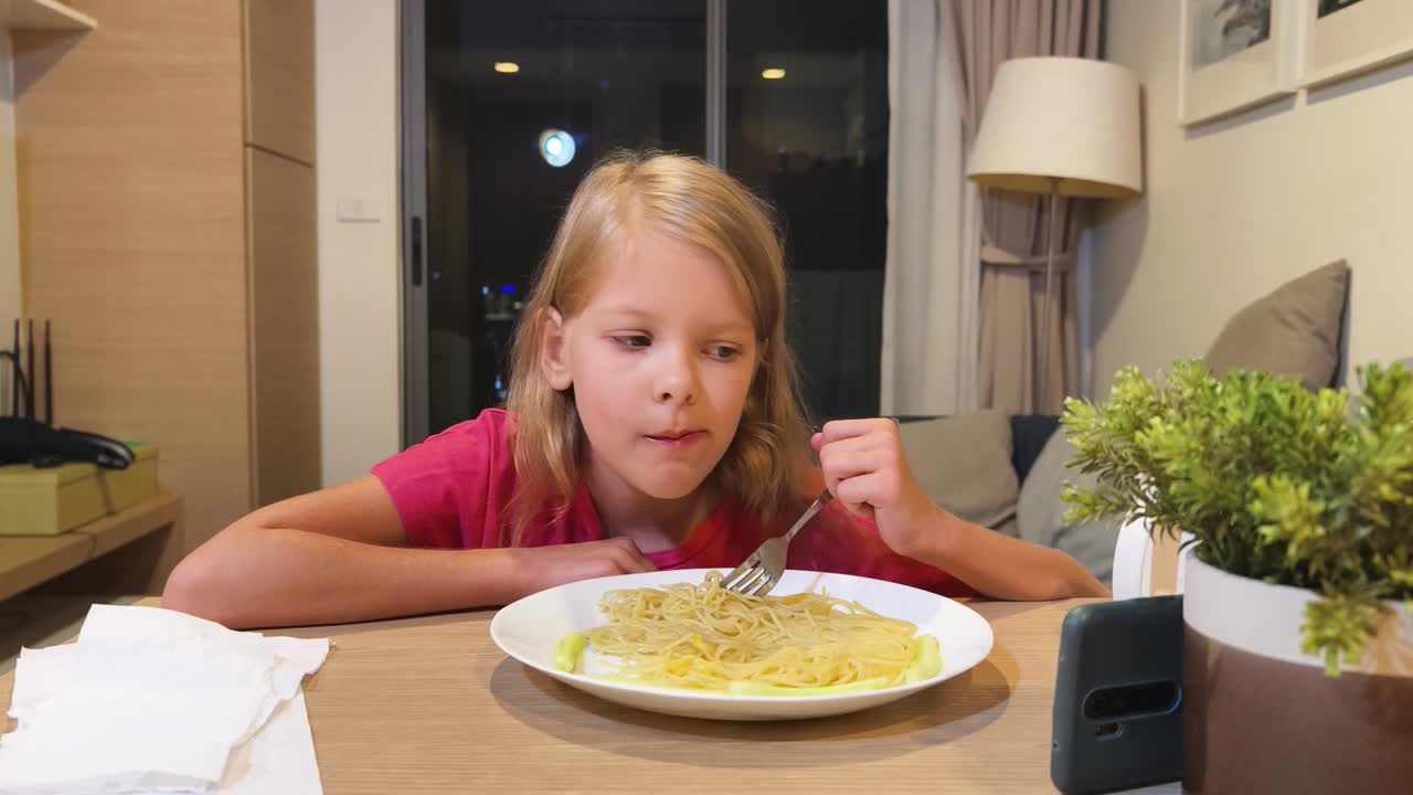 Bambina che mangia spaghetti