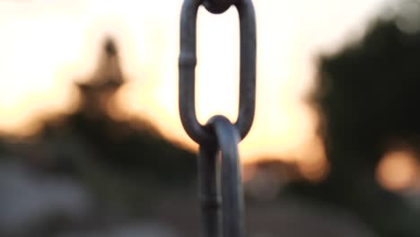 una fuerte cadena de hierro se enfoca contra el telón de fondo de una puesta de sol que disminuye