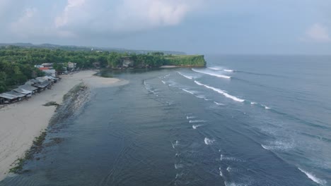 top down drone shot over tropical balangan beach peninsula in uluwatu bali indonesia with crashing waves and turquoise water