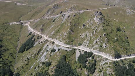 Drone-view-of-the-road-and-vehicle-going-around-the-hill