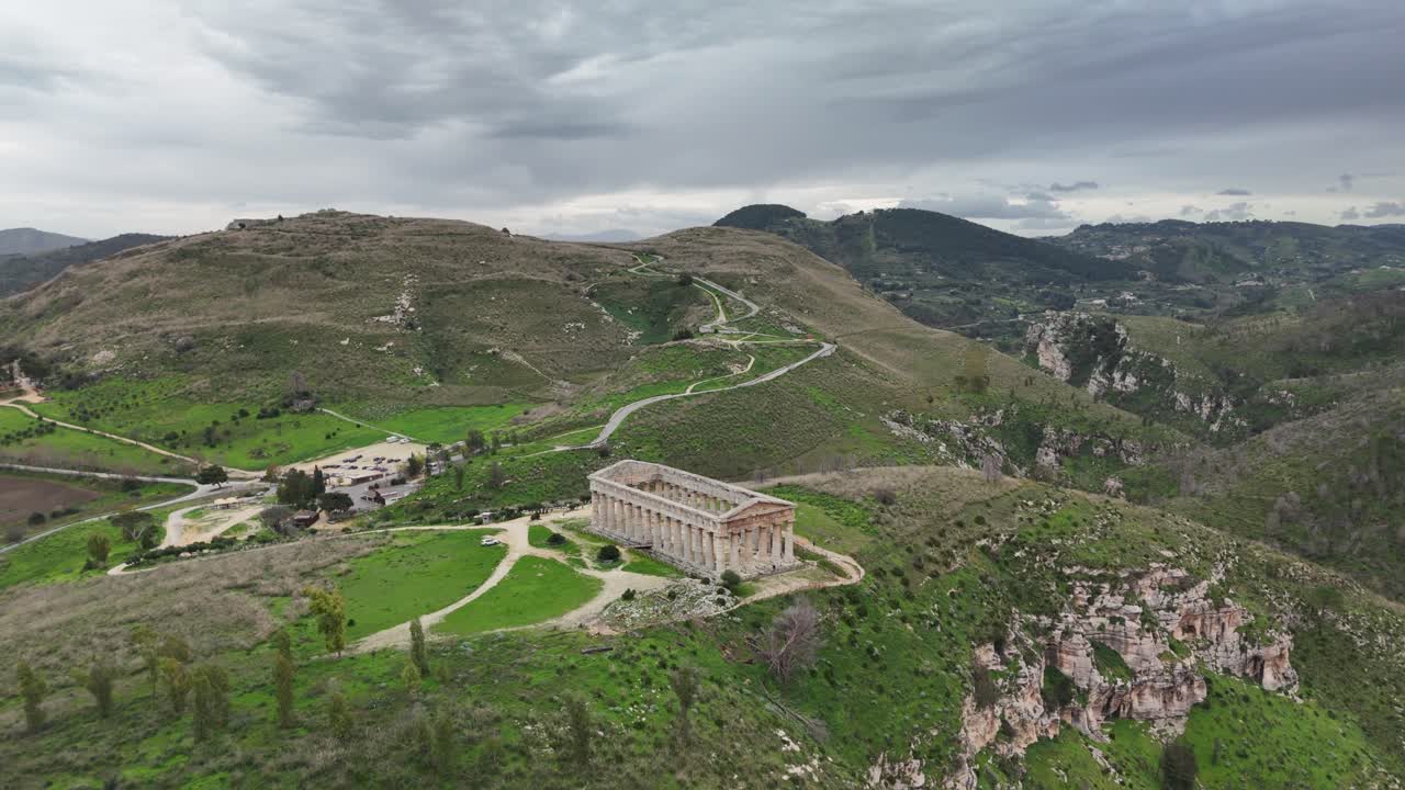 Antiche rovine su una collina sotto un cielo nuvoloso con vista su un paesaggio verde