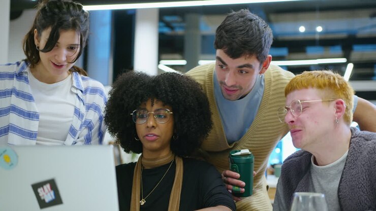 Cheerful Coworkers Using Laptop and Discussing Business Ideas in the Office