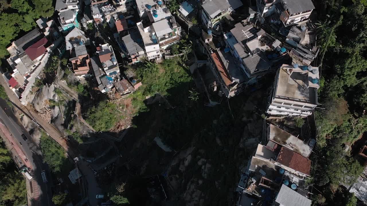 두 형제 산의 경사면에 있는 작은 리우데자네이루 파벨라 차카라를 보여주는 공중 위에서 아래로 뒤로 기울이고 위로 기울입니다.