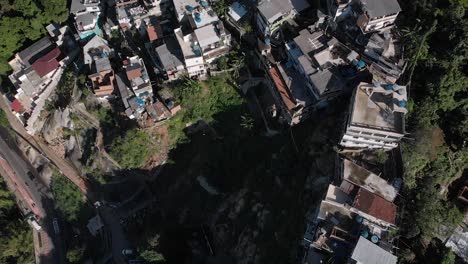 backwards aerial top down and tilt up showing the small rio de janeiro favela chacara on the slopes of the two brothers mountain