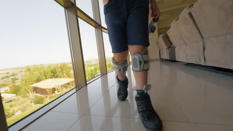 niño con sistema de caída de pies caminando en el interior