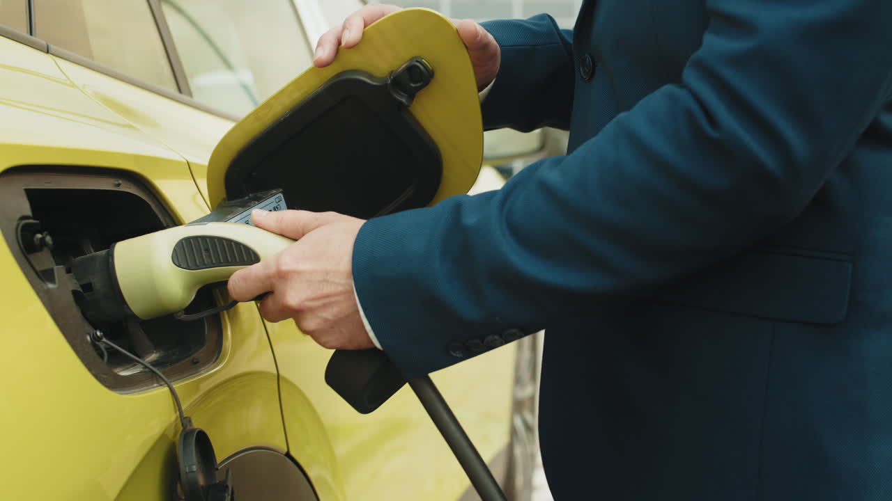 hombre cargando coche eléctrico