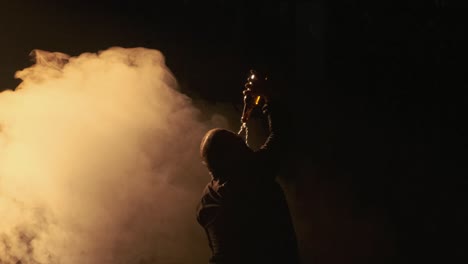 el hombre bebe alcohol en la oscuridad y la niebla.