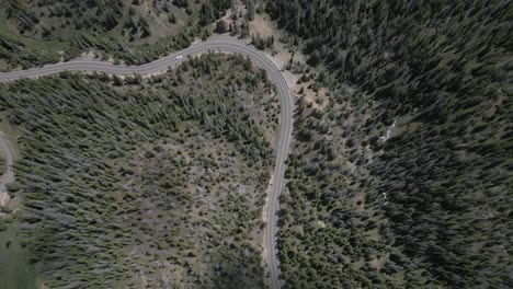 Weißes-Fahrzeug-Fährt-Serpentinen-Autobahn-Im-Immergrünen-Wald-In-Den-Grafschaften