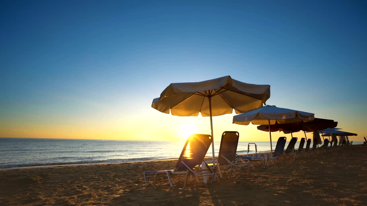 Splendida vista del tramonto serale di un lussuoso resort sabbioso con lettini da spiaggia e ombrelloni, sfondo in loop