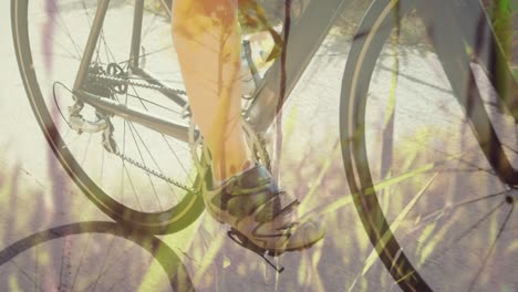 Animation-of-grass-over-caucasian-woman-cycling
