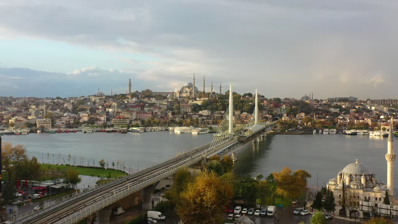 amplia antena mientras un dron pasa por los tejados de los edificios residenciales en estambul, turquía, revelando el puente del metro halic y la hagia sophia en la distancia