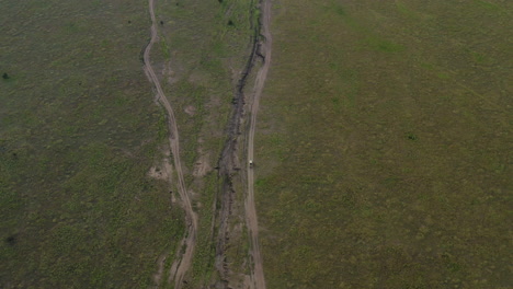 Safari-tour-car-on-the-road-of-Serengeti-National-park-in-the-evening,-Tanzania