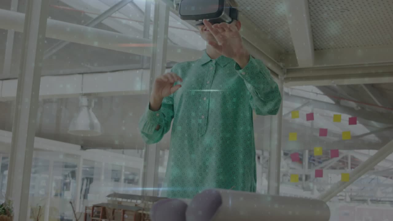Ingegnere che indossa un visore VR che indica di avviare dati olografici, controllando per confermare la selezione