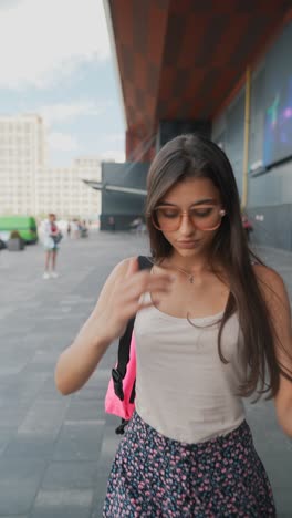 una mujer joven caminando por una ciudad.