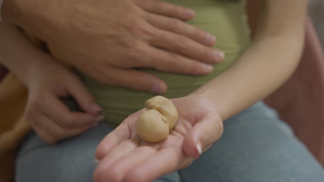 pregnant couple holding toy baby