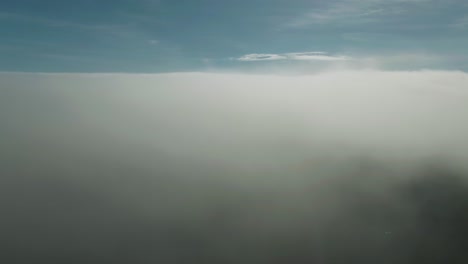 aerial flight through the clouds moving towards the drone camera above magdalen islands in northern quebec, canada