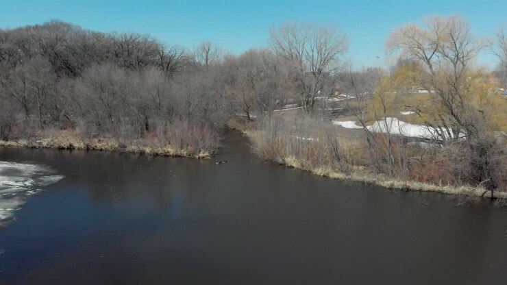 Video aereo con drone dal lago Susan a Chanhassen, Minnesota, che si allontana e si alza per rivelare la linea del ghiaccio mentre si scioglie con l'arrivo della primavera.