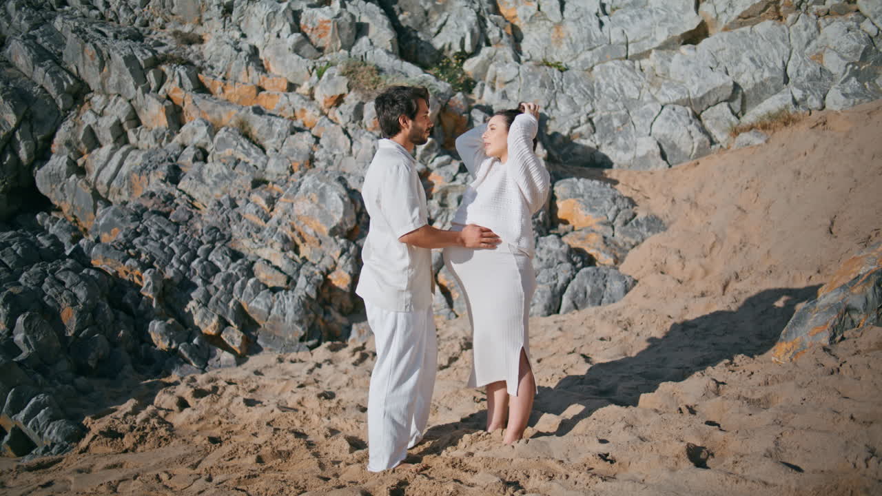 바위가 있는 해안가에서 아기를 기다리는 가족들이 함께 빛 날을 즐기고 있습니다.