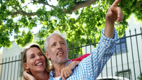 retrato de una pareja madura está abrazando y señalando