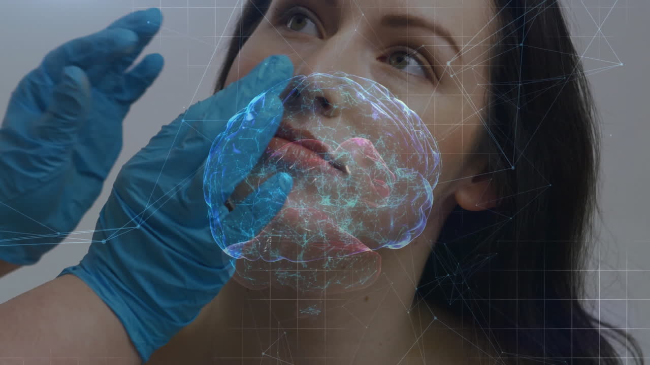 Clinico che posiziona guanti blu sul viso del paziente, proiettando un ologramma medico del cervello con sovrapposizione a griglia