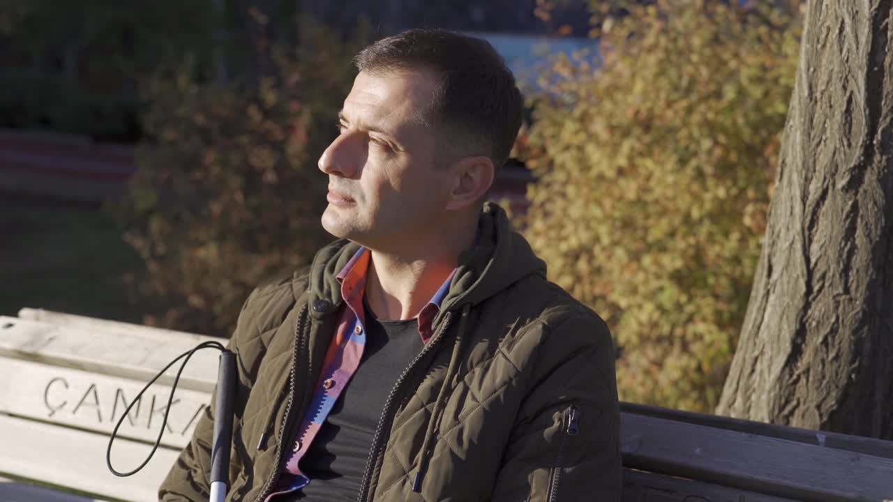 el ciego sentado en el banco respira profundamente.