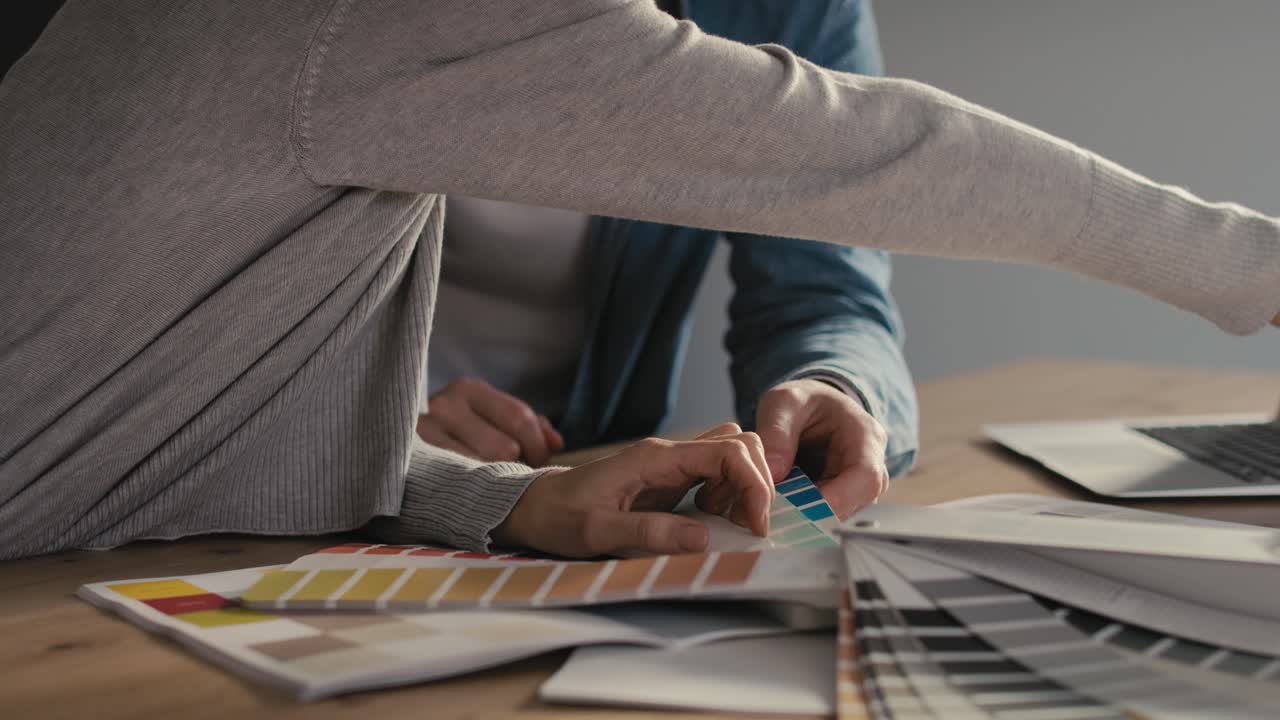 detalle de una pareja eligiendo colores para una casa nueva.