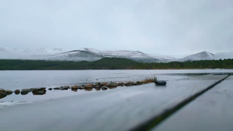 Static-shot-of-lake-with-waterbirds-on-surface-and-mountain-ridge-in-background