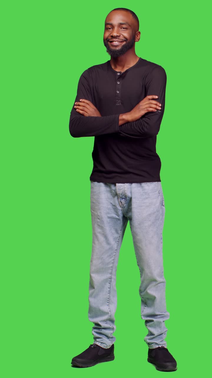 Video verticale: vista frontale di una persona cordiale e informale che posa a figura intera su greenscreen