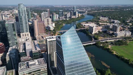 circling the sailboat building to reveal lady bird lake and the austin skyline