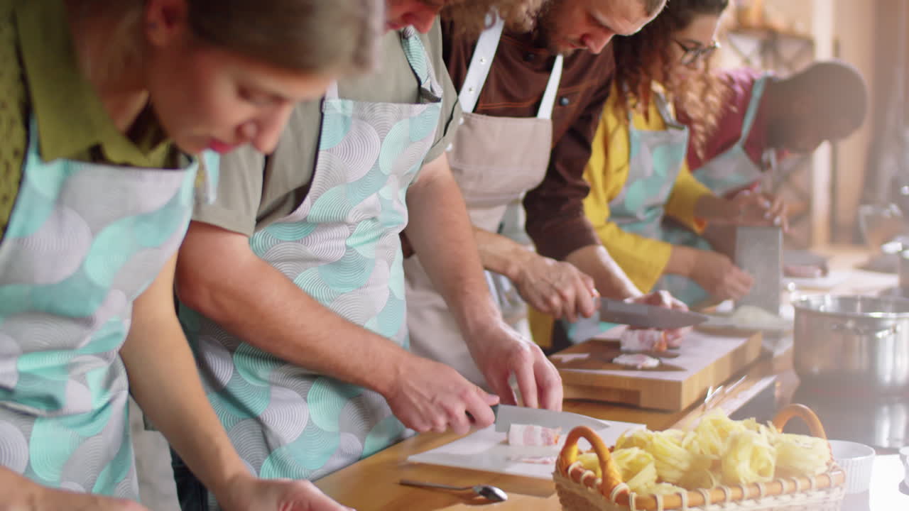 Diverse Students and Chef Cutting Pork at Cooking Master Class