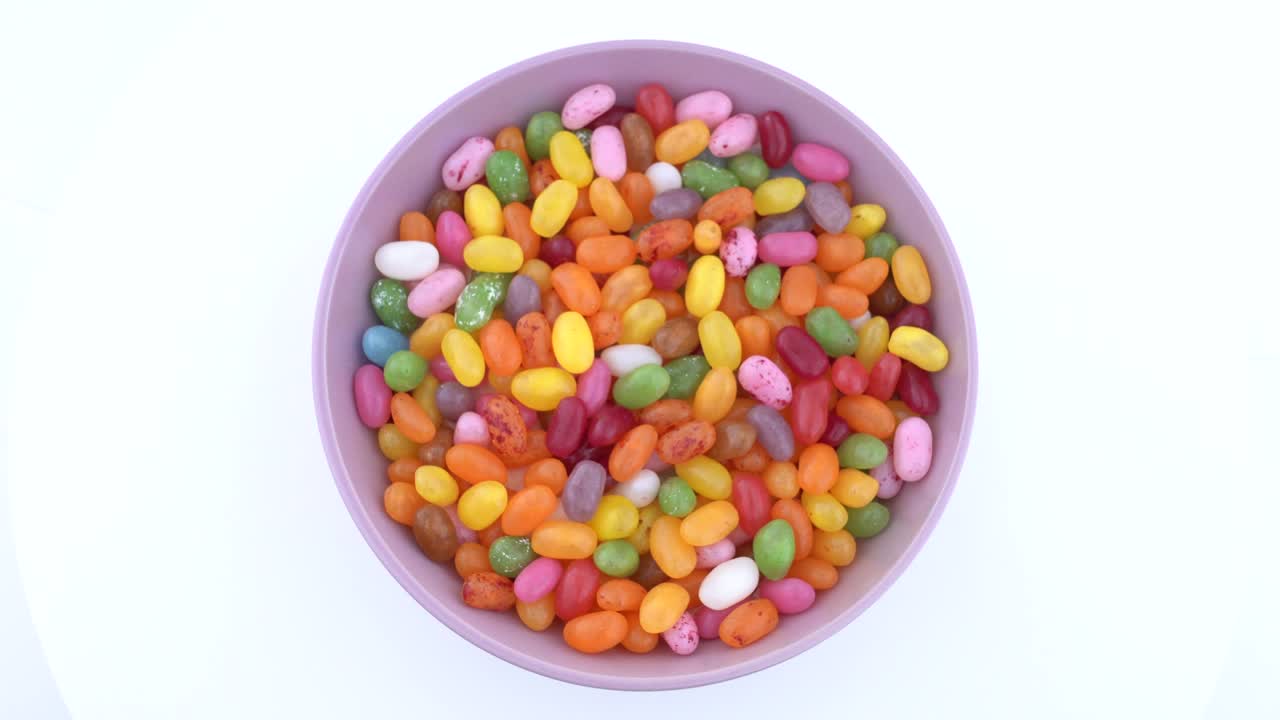 una pila de dulces de gelatina de azúcar en forma de frijol. girando. vista desde arriba o por encima.