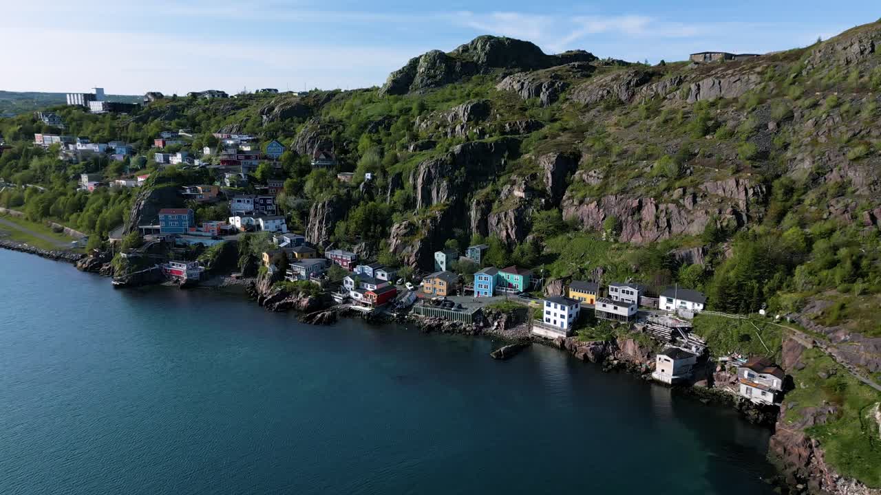 Slow drone spin of the Outer Battery in St. John's, Newfoundland, Canada, with Signal Hill looming above. The colourful houses line the cliffside.