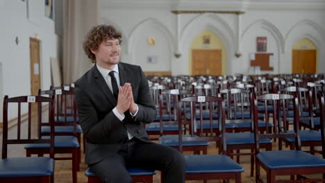 man in formal wear sitting in large audience hall