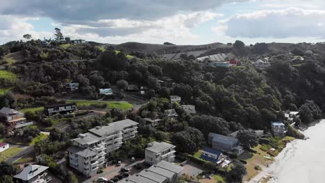 drone shot on waiheke island raising up to reveal the hidden vineyards on the hill