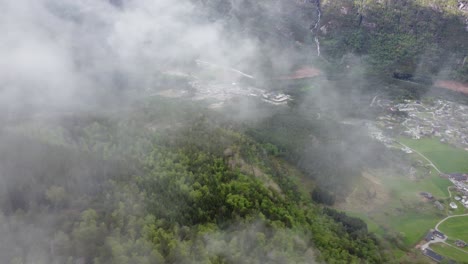 hermosa vista a gran altitud a través de las nubes que pasan de kinsarvik hardanger - antena giratoria que pasa a través de nubes claras que observan el pueblo de kinsarvik abajo