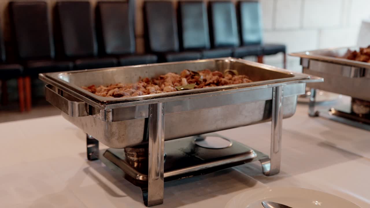 Steaming hot food served in a stainless steel buffet tray for catering display