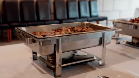 steaming hot food served in a stainless steel buffet tray for catering display