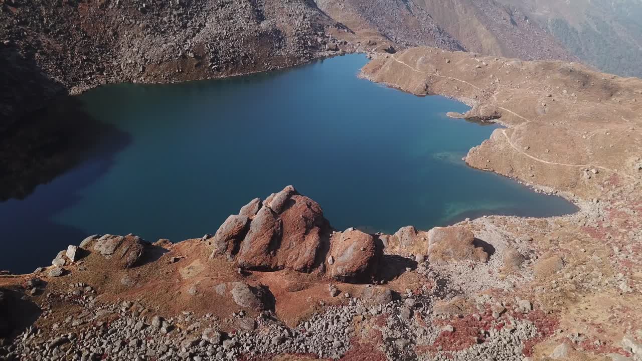 A stunning aerial view of Gosaikunda Lake in Solukhumbu shows its sacred blue water set amid rugged mountain terrain. The high-altitude scenery highlights the lake’s natural beauty