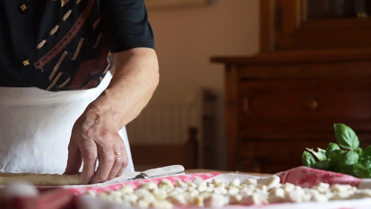 Donna in cucina prepara gnocchi, cucina italiana.