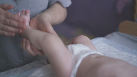 Das-Baby-Liegt-Auf-Dem-Wickeltisch-Und-Die-Krankenschwester-Führt-Eine-Beinmassage-Durch