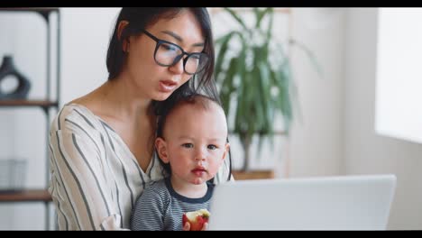 madre trabajando con el bebé en casa