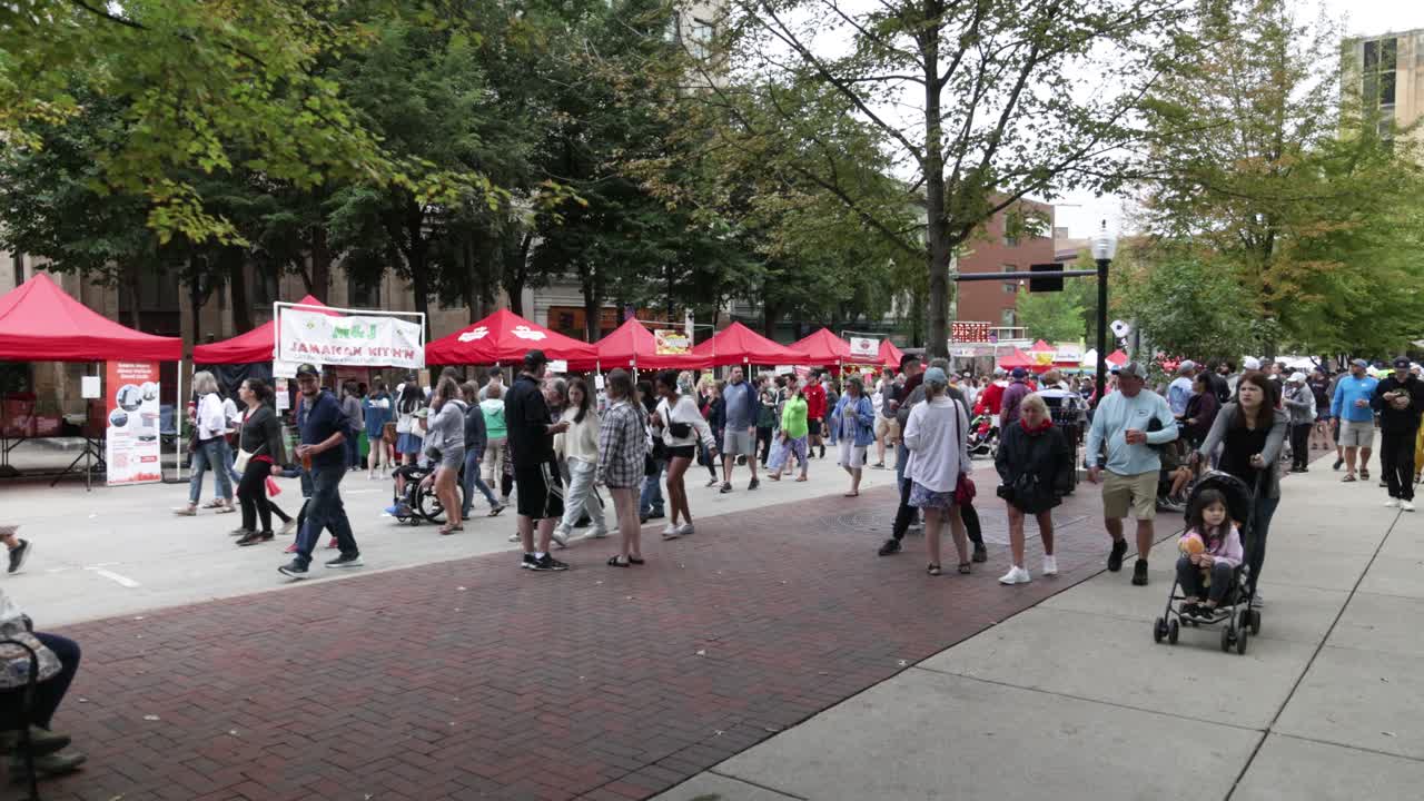 Group of people attending Taste of Madison food and beverage festival in Madison, Wisconsin with gimbal video moving forward.
