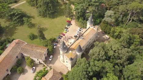 Murviel-les-Béziers,-France---May-2018-:-Aerial-drone-view-of-an-exhibition-of-old-vintage-cars-in-front-of-a-castle