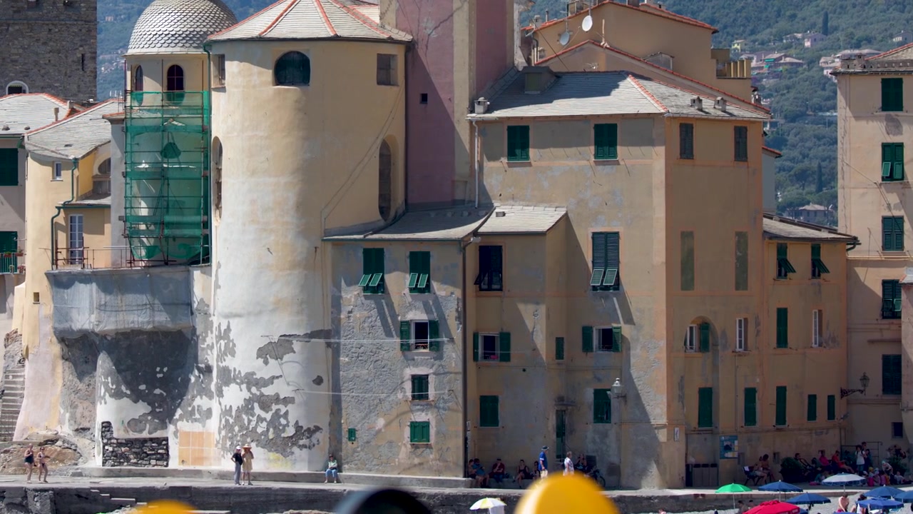 Panoramica di vivaci edifici costieri e una basilica storica sotto la luminosa luce solare mediterranea