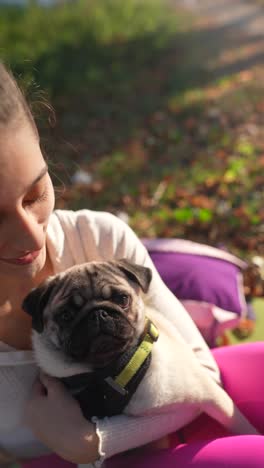 woman laughing with her pug dog