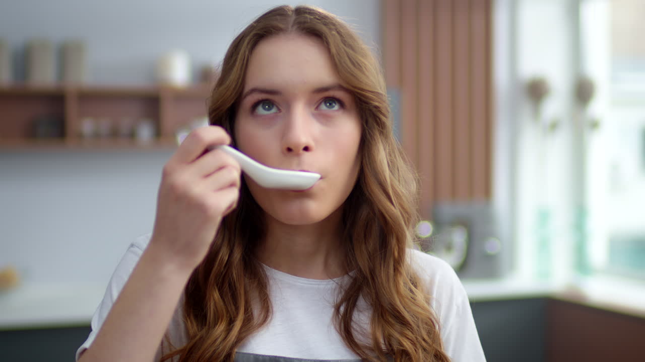 집 주방에서 뜨거운 음식을 맛보는 아름다운 여성. 실내에서 해산물  ⁇ 새를 맡는 소녀.